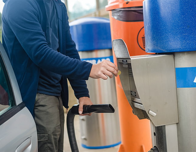 man putting money into vacuum at car wash