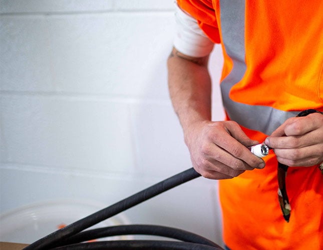 hands of Reliable Plus technician holding hose