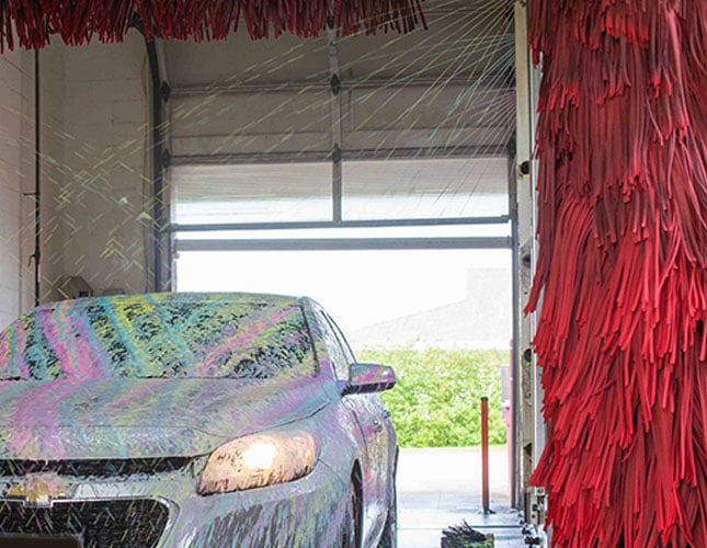 car wash chemicals being sprayed on car in carwash