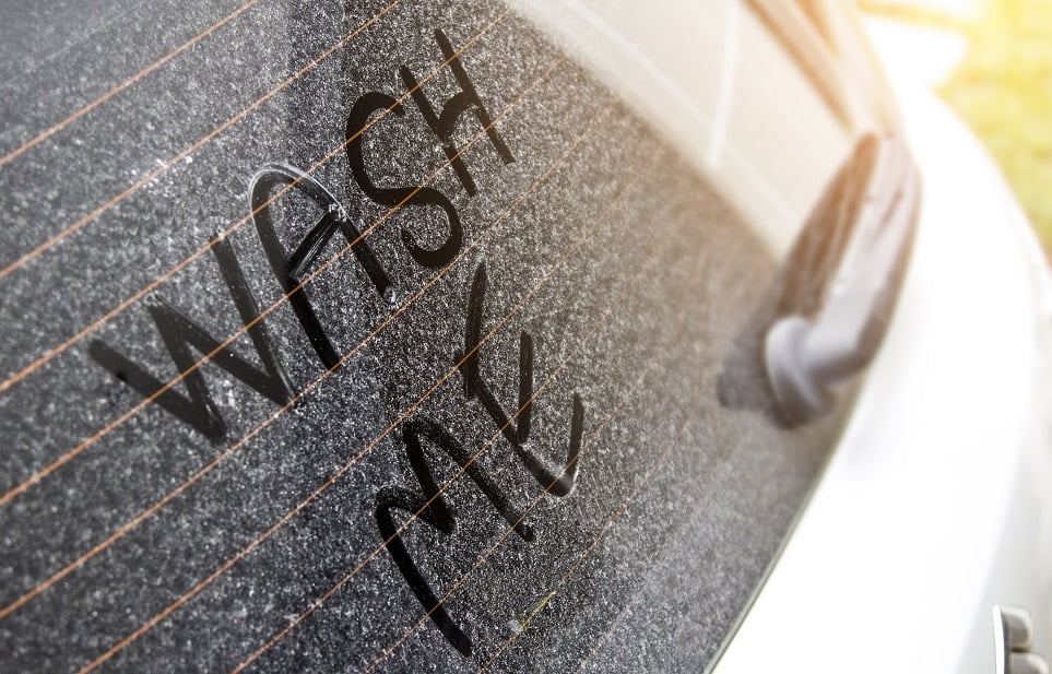 'wash me' written on dirty car